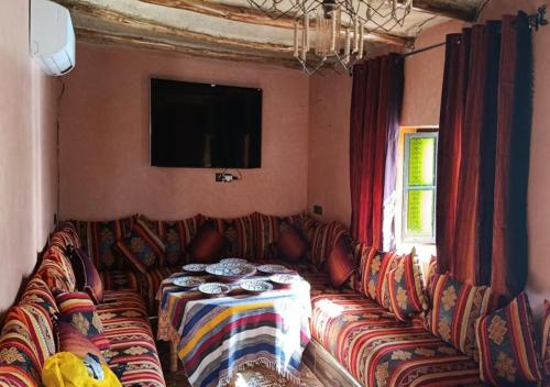 a living room with a couch and a tv at Ferme Panorama in Ouazzane