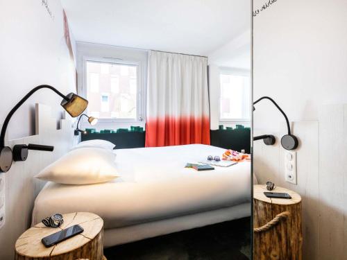 ein Schlafzimmer mit einem Bett mit zwei Lampen und zwei Tischen in der Unterkunft ibis Styles Thonon-les-Bains in Thonon-les-Bains