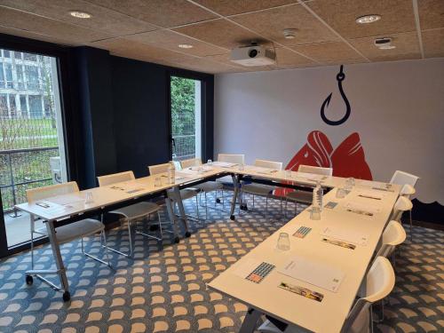ein Konferenzraum mit Tischen und Stühlen und einem großen Fenster in der Unterkunft ibis Styles Thonon-les-Bains in Thonon-les-Bains