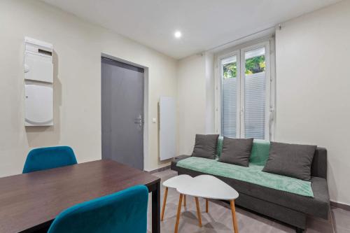 a living room with a couch and a table at Appartement RDC avec parking au centre-ville in Charleville-Mézières