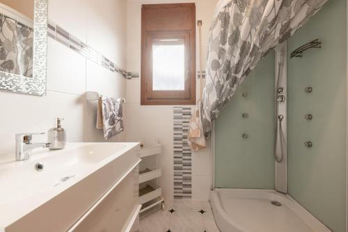 un bagno bianco con lavandino e doccia di Paradise a Miami Platja