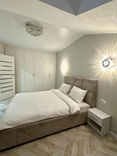 a bedroom with a large bed with white sheets at City Apartments in Ivano-Frankivsʼk