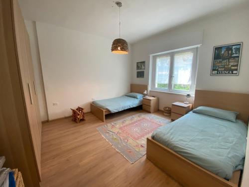 a bedroom with two beds and a window at Appartamento Spormaggiore in Spormaggiore
