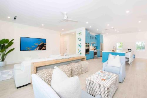 Driftwood VillageにあるCaribe Sun - Modern Villa with Pool! Walk to the Rum Point Club & Kaiboのリビングルーム(白い家具、青いキャビネット付)