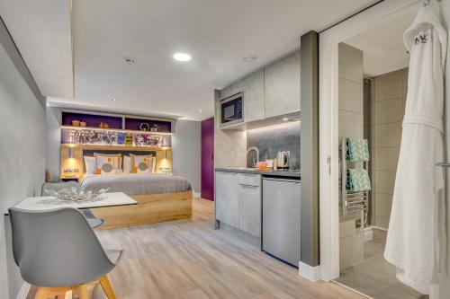 a bedroom with a bed and a desk and a kitchen at The Glassworks in Headingley