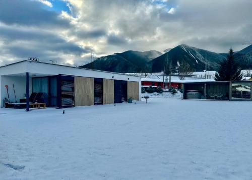 a building in the snow with mountains in the background at Challet Závažná Poruba in Závažná Poruba