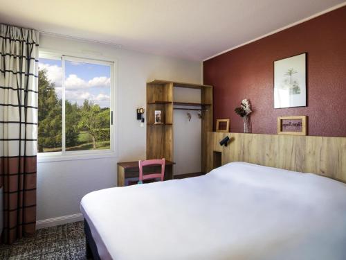 a bedroom with a white bed and a window at Greet Hôtel Castres Saix in Saix