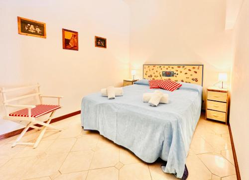 Un dormitorio con una cama grande y una silla. en Hostdomus - Phil House, en Finale Ligure