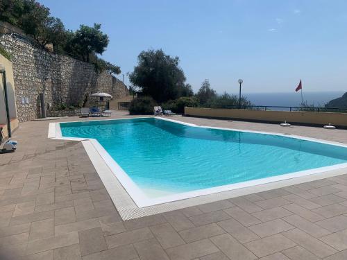 Una piscina con agua azul en un patio. en Hostdomus - Phil House, en Finale Ligure