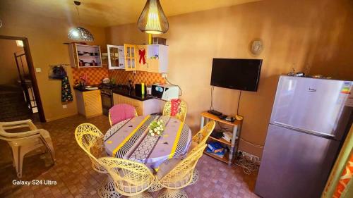a kitchen with a table and chairs and a refrigerator at Apartment Exotica in Flic-en-Flac