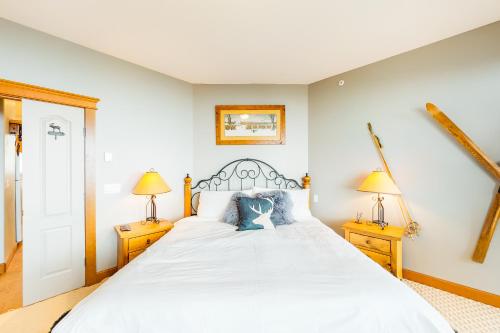 a bedroom with a large white bed with two lamps at Tree Tops 13 in Big White