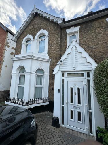 a white front door of a brick house at Parchmore House in Thornton Heath