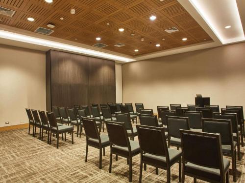 a conference room with chairs and a large screen at Pullman Lima Miraflores in Lima
