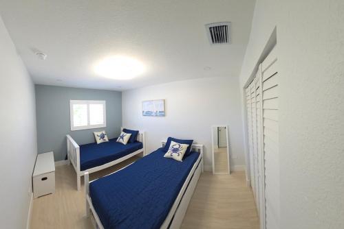 a bedroom with two beds with blue sheets at Direct access Canal front with Pool 2 bed 2 bath in Marathon