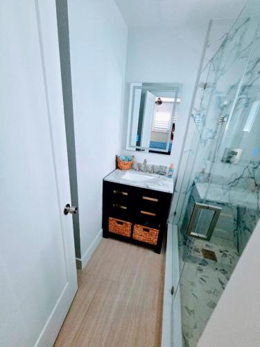 a bathroom with a sink and a glass shower at Direct access Canal front with Pool 2 bed 2 bath in Marathon
