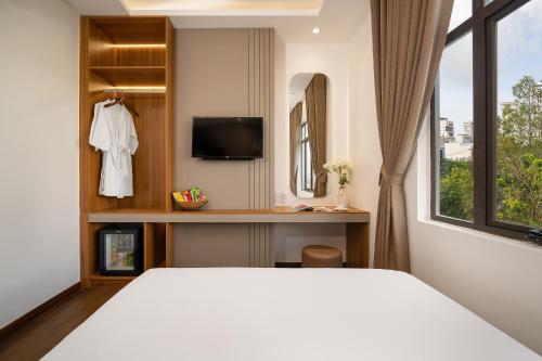 Un dormitorio con una cama blanca y una ventana. en Salux Hotel, en Da Nang