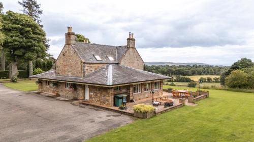 an old brick house with a patio in a field at Balnagown Estates in Kildary