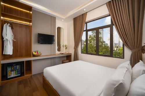 Una habitación de hotel con una cama y una ventana. en Salux Hotel, en Da Nang