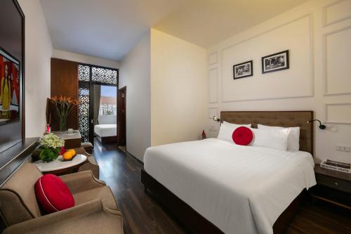 a bedroom with a large white bed and red pillows at Victory Legend Hotel - In Hanoi Central in Hanoi