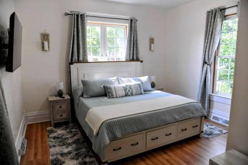 Un dormitorio con una cama y dos ventanas en 3 Bed Bath with yard and Fire Pit- Charming Small Town Exploring, en Bremen