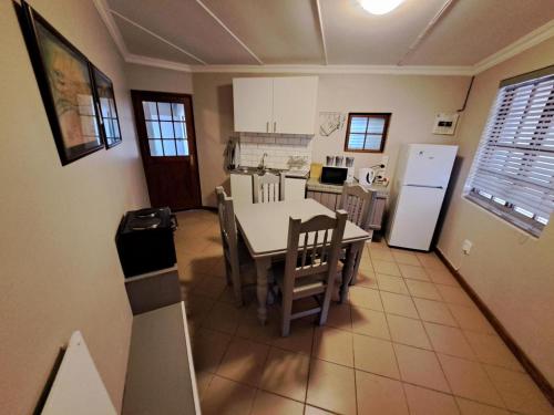 a kitchen with a table and a refrigerator at Grace Walk Guest House in Swellendam