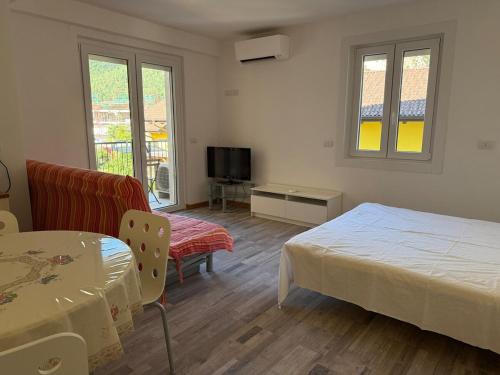 テンノにあるStudio apartment near the lakeのベッドとテーブルとテレビのある寝室