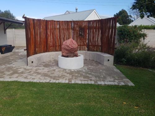 a statue in a yard next to a wooden fence at Grace Walk Guest House in Swellendam