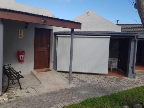 a house with two white covers on a patio at Grace Walk Guest House in Swellendam