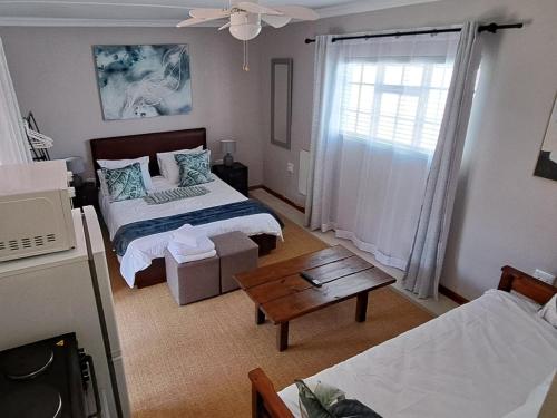 a living room with two beds and a table at Grace Walk Guest House in Swellendam