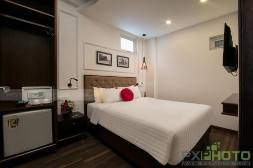 a bedroom with a bed with a red pillow on it at Victory Legend Hotel - In Hanoi Central in Hanoi