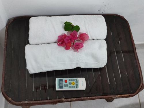 a table with towels and a remote control and flowers at Kanus Ayangue in Ayangue