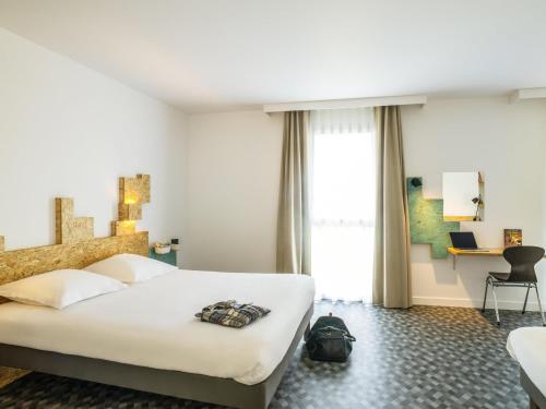 Ένα ή περισσότερα κρεβάτια σε δωμάτιο στο greet Hotel Rennes Pace