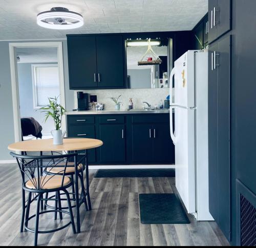 a kitchen with blue cabinets and a table and a refrigerator at 1 BR Cozy Apartment with Fire Pit Short walk to town in Nappanee