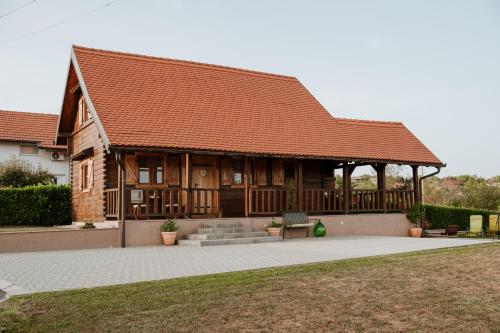 une grande maison en bois avec un porche dans l'établissement Kuća za odmor Rustica, à Kutina