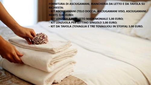 a person putting towels on top of a bed at Villa Aurora 1 in Torre Lapillo