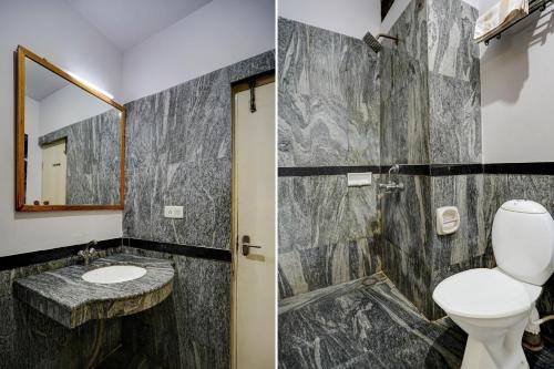 a bathroom with a toilet and a sink and a mirror at Hotel O ALT pods in Bengaluru