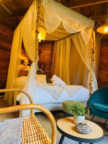 a bedroom with two beds with a canopy at Refuge de Campagne Le Chalet in Chaix