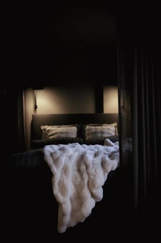 Stylish City Suite in the Heart of Jyväskylä في يوفاسكولا: غرفة نوم بسرير وبطانية بيضاء