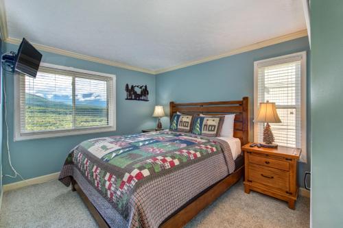 a bedroom with a bed and two windows and a television at TeeTop Getaway by Avada Properties in Pittman Center