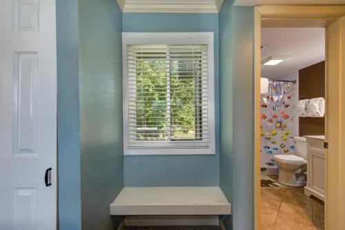 a bathroom with blue walls and a window and a bench at TeeTop Getaway by Avada Properties in Pittman Center