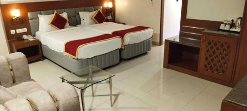 LingampalliにあるCollection O Hyderabad Central Universityのベッドとソファのあるホテルの部屋