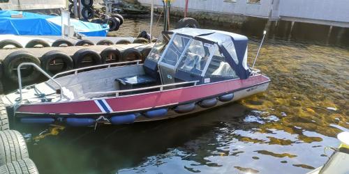 a boat tied up to a dock in the water at ASFeriehus in Flekkefjord