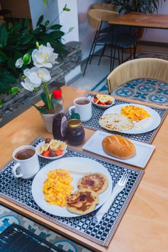 瓜塔佩Guatapé Country House Hotel的桌子上摆满了早餐食品和咖啡