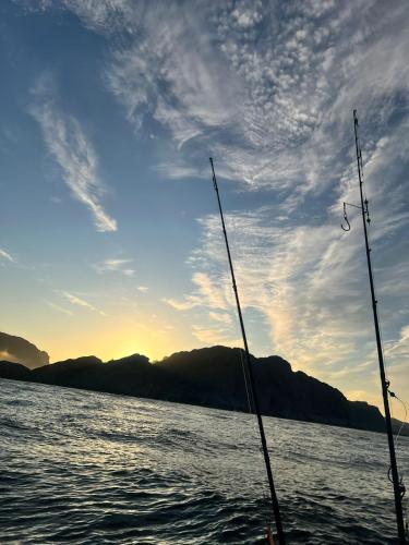 two fishing poles on a boat in the water at ASFeriehus in Flekkefjord