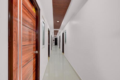 a hallway with wooden doors and white walls at Hotel O De' BVL Grand in Hyderabad