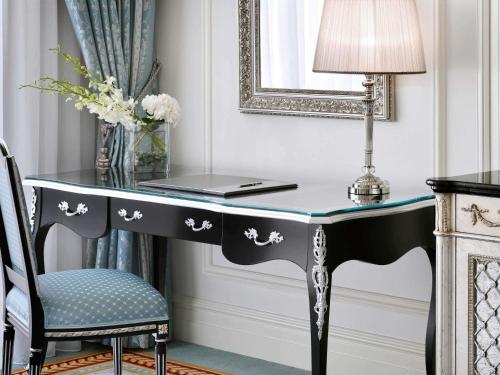 a desk with a lamp and a laptop on it at Raffles The Palm in Dubai