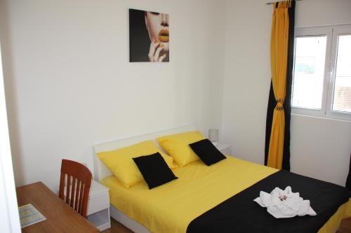 1 dormitorio con 1 cama amarilla, mesa y ventana en Apartment Nina, en Split