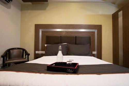 a bedroom with a bottle of wine on a bed at Collection O Karimbankuthu Waterfalls Thekkady Formerly Thoufeeq Tourist Home in Idukki