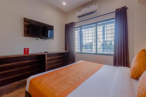 ムンバイにあるCollection O Andheri Railway Station Formerly Hotel Fortune Eliteのベッドとテレビと窓のある寝室