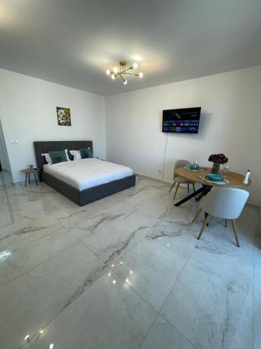a bedroom with a bed and a table and a television at Urban Sud Residence in Giroc